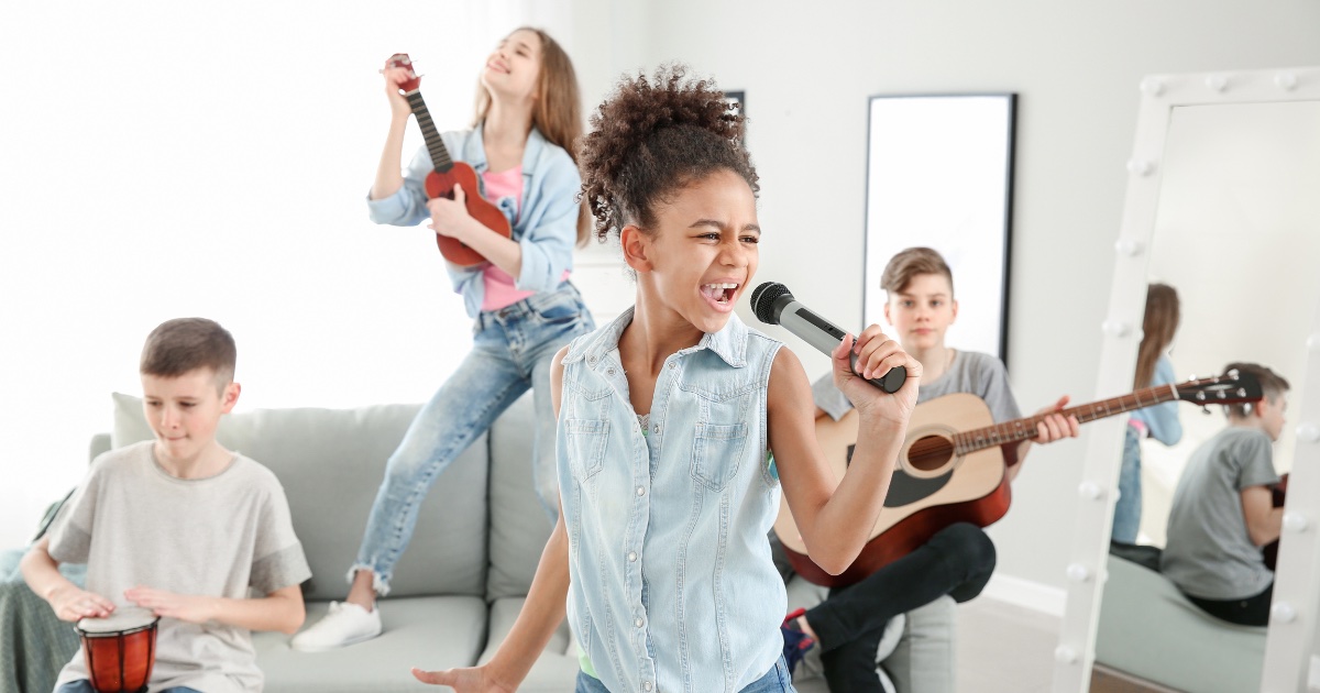 Girl singing with other kids around her playing instruments and dancing